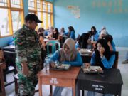 Babinsa Bukit Damai Kopda Achmad Fahri Kawal Langsung Distribusi Makan Bergizi Gratis di SMKN 1 Maluk