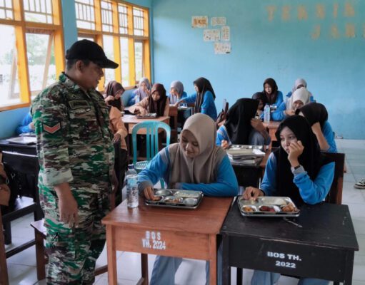Babinsa Bukit Damai Kopda Achmad Fahri Kawal Langsung Distribusi Makan Bergizi Gratis di SMKN 1 Maluk