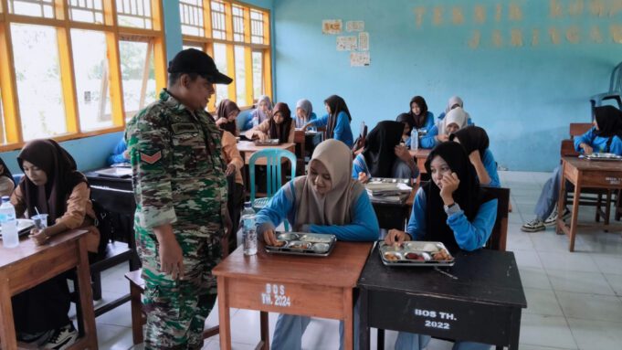 Babinsa Bukit Damai Kopda Achmad Fahri Kawal Langsung Distribusi Makan Bergizi Gratis di SMKN 1 Maluk